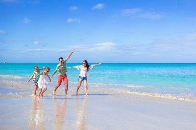 Book summer travel early Happy family on white beach on summer vacation