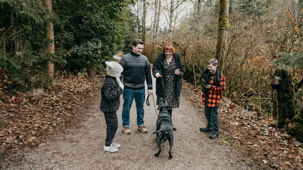 family outside on a natue walk in the fall walking their pet dog animal is a dog dna test worth it