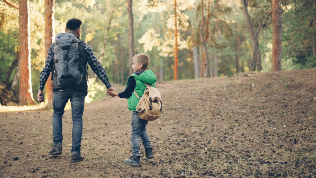 dad and son hiking outdoors camping backpacking with kids