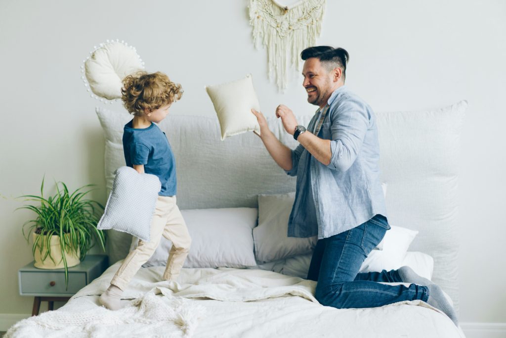 dad and son having a pillow fight kids room wall decor ideas