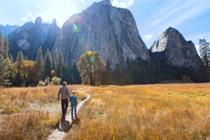 best hiking trails for kids dad and son at a nation park hiking outdoors outside nature hike back view of active family of two, father and son, enjoying valley and mountain view in yosemite national park, california, active family vacation concept