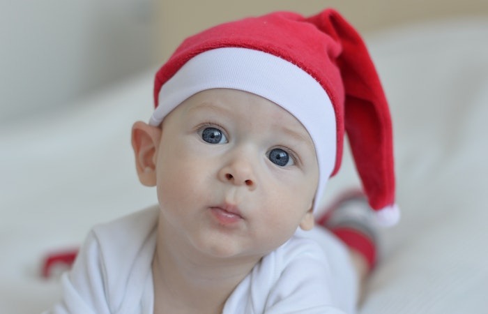 Baby Wearing Red Christmas Hat on White Textile