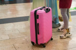 package deals for family vacations - woman with luggage traveling at airport