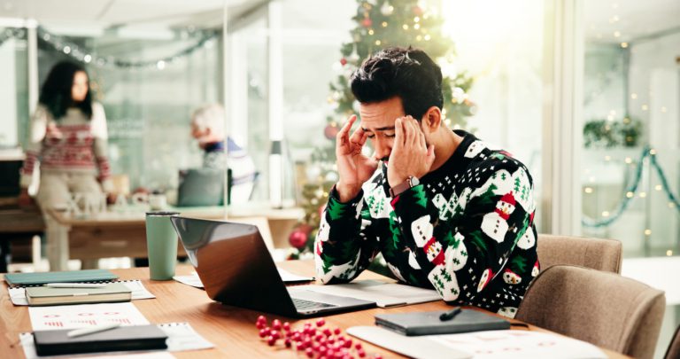 Headache, christmas and businessman in office with laptop for stress, burnout or fatigue for workload. Exhaustion, tired and financial advisor with migraine for documents and computer in xmas season. Work Life Balance During the Holiday Season
