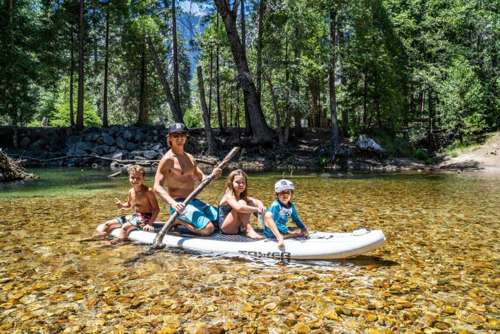family on paddle board Book summer travel early