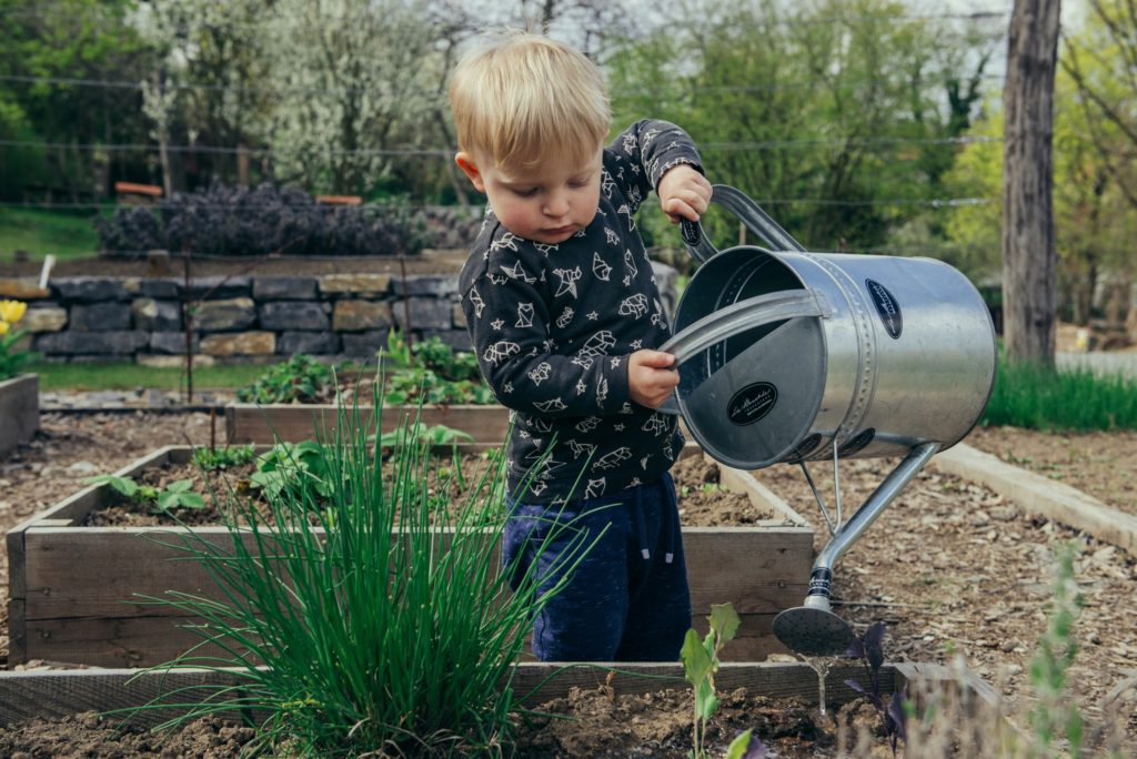 little kid gardening outside how to build a kid-friendly garden