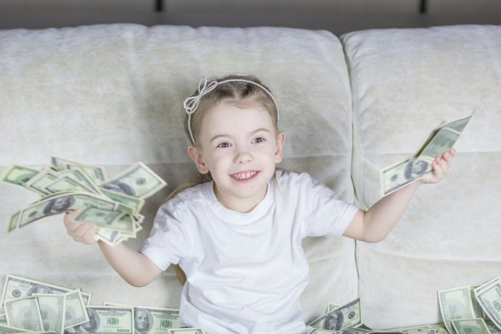 kid holding money investing for kids future