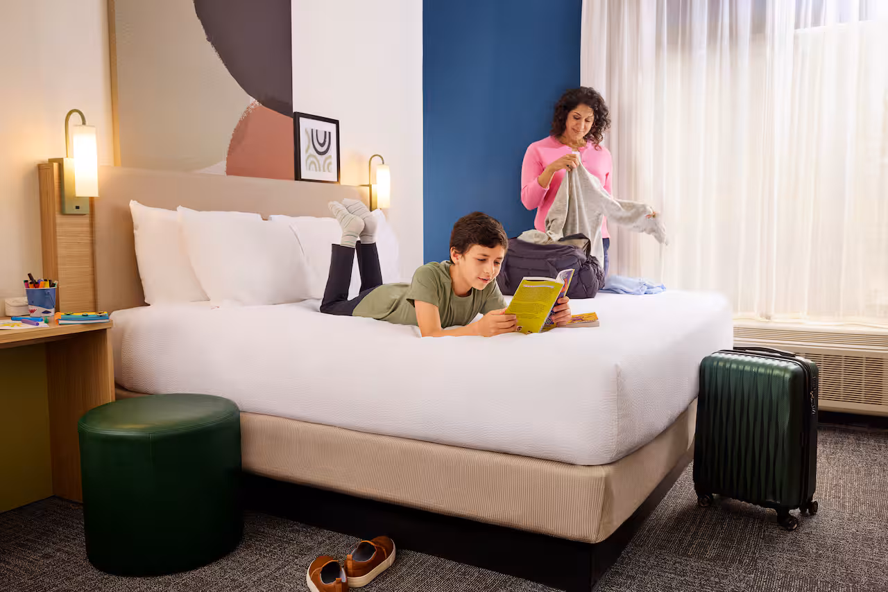 kid on bed at hilton spark Affordable Family Summer Vacation Ideas 