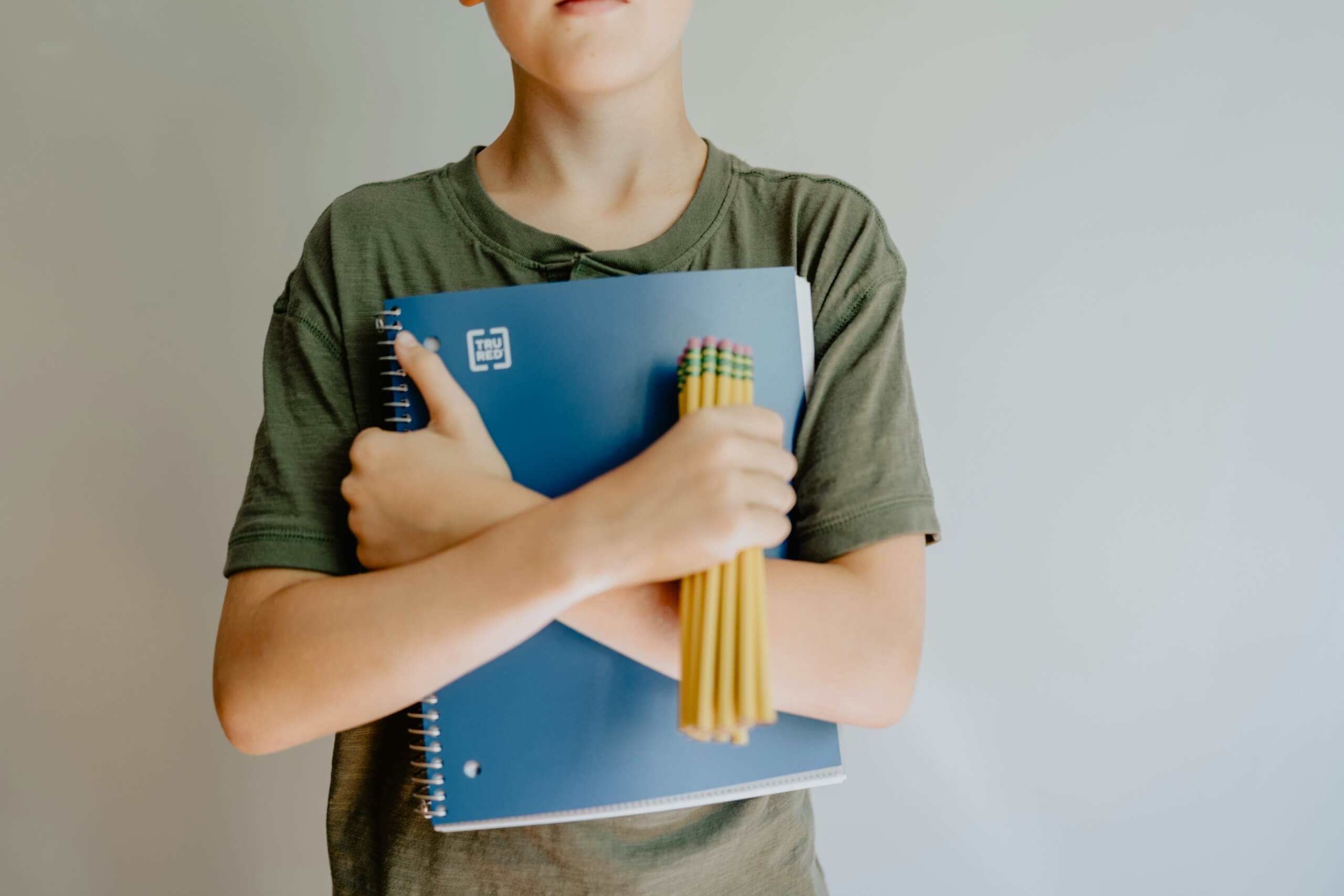 back to school shopping list for parents kid holding back to school supplies