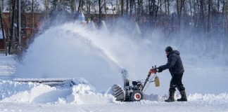 Man removing snow with snow blower - winter checklist for home
