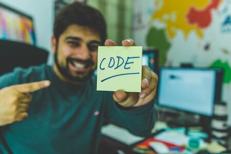 Man In Grey Sweater Holding Yellow Sticky Note - entry level programming jobs