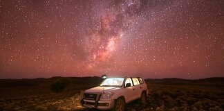 White Suv on Brown Field Under Starry Night - difference between all wheel drive and 4 wheel drive