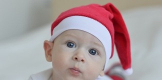 Baby Wearing Red Christmas Hat on White Textile