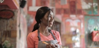 Shallow Focus Photo of Woman Smiling While Holding Pen and Paper - highest paying jobs for 16 year olds