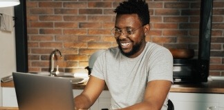 Man smiling at laptop - fun jobs near me