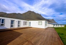 Mountain Across Houses on Green Grass Field Under Clear Blue Sky - how to install a deck