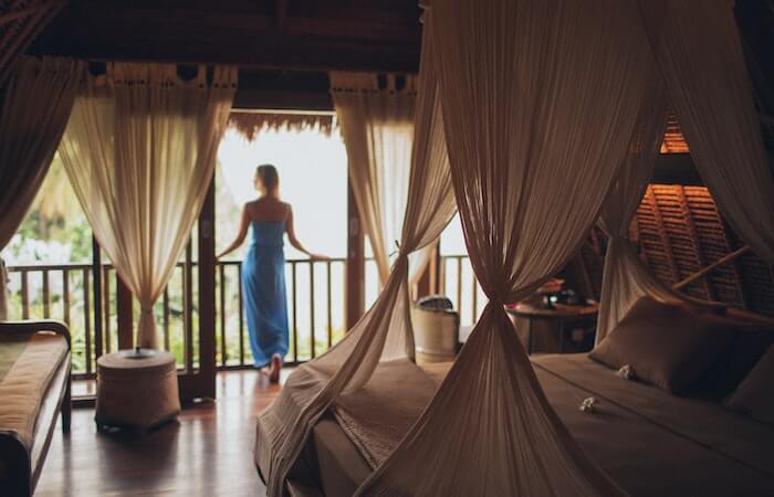 Woman Leaning on Handrail in Room - safety tips when staying in a hotel