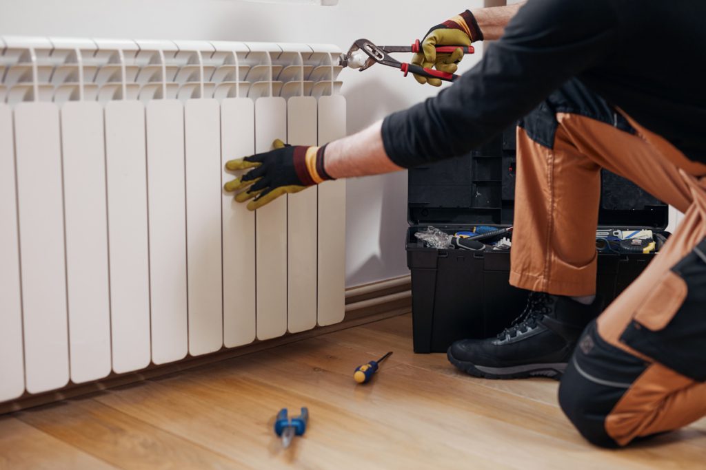 Central heating mechanic and handyman fixing home radiator, gas crisis and seasonal issues.Home Maintenance Checklist for Winter 